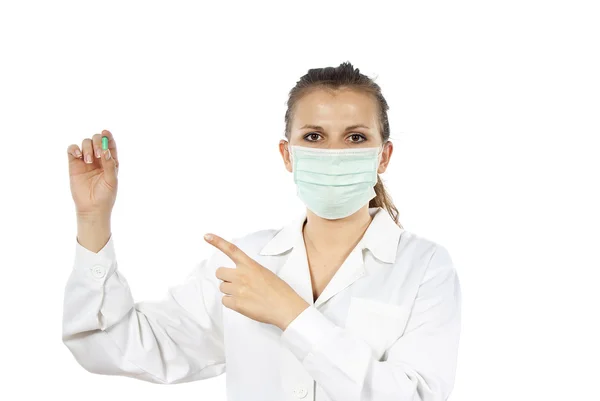 Enfermeira usando uma máscara segurando um comprimido — Fotografia de Stock