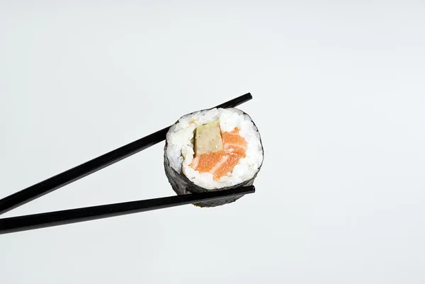 Sushi en un palo sobre un fondo de gris — Foto de Stock