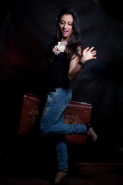 Красивая восточная девушка, стоящая на чемодане — стоковое фото