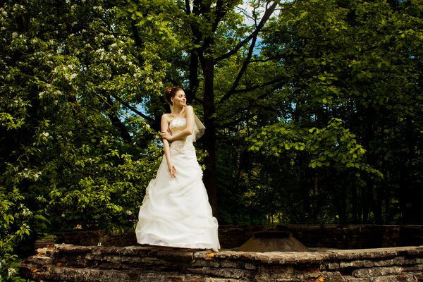 Beautiful girl bride green foliage of apple green twig wedding dress hem