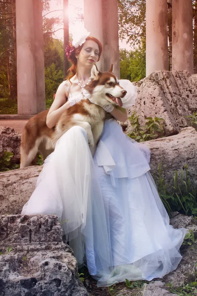 Mooi meisje in witte jurk met hond — Stockfoto