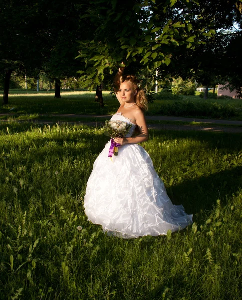 Belle fille dans une robe de mariée avec bouquet — Photo