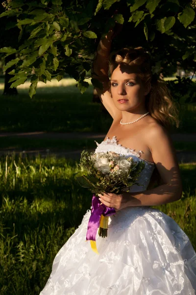 Bella ragazza in un abito da sposa con bouquet — Foto Stock