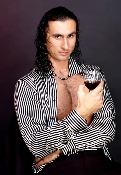 erotik bir görüntüde bir bardak şarap ile güzel bir adam