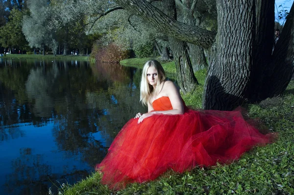 Piękna dziewczyna w czerwonej sukience nad jeziorem — Zdjęcie stockowe