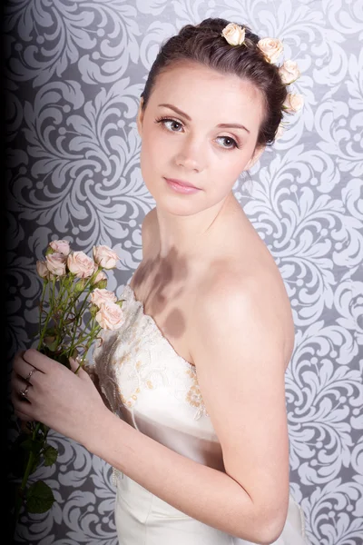 Leuk meisje in een trouwjurk met een boeket — Stockfoto