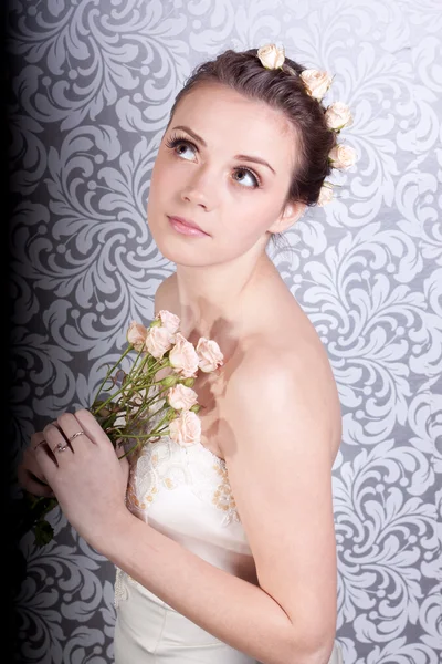 Cute girl in a wedding dress with a bouquet — Stock Photo, Image