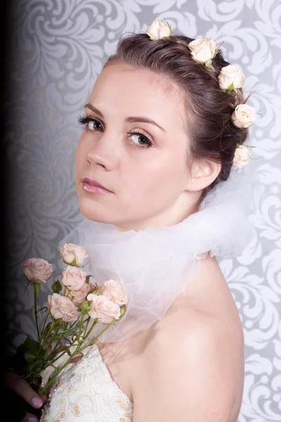 Linda chica en un vestido de novia con un ramo — Foto de Stock