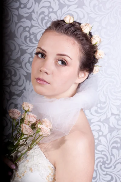 Roztomilá dívka ve svatebních šatech s kyticí — Stock fotografie
