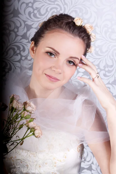 Linda chica en un vestido de novia con un ramo — Foto de Stock
