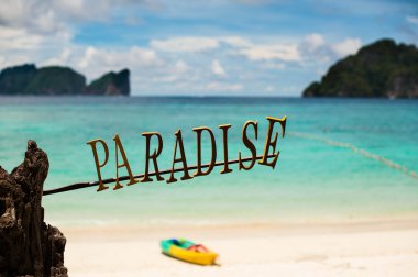 Sign Paradise on the background of the tropical beach clipart