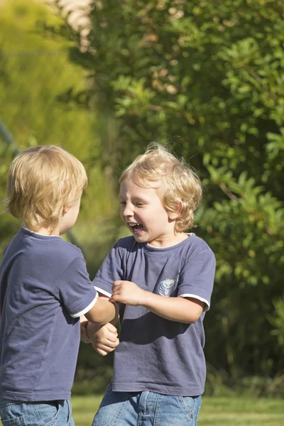 两个金发男孩在花园里的视图. — 图库照片