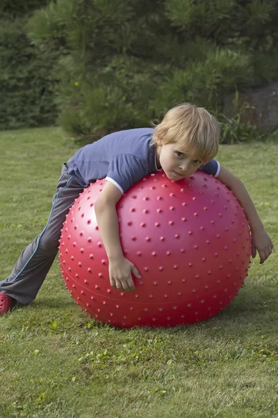 The blond boy lies on a relaxing balloon — Stock Photo, Image