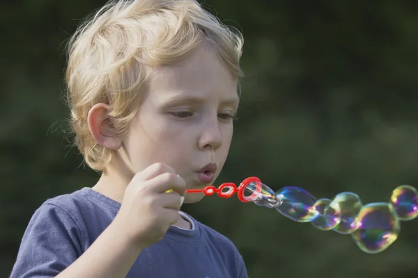 Vista lateral de un niño con burbujas de jabón . —  Fotos de Stock