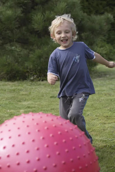 The blond boy kicking the relaxing balloon — Stock Photo, Image