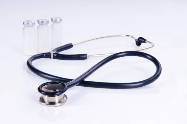 Medyczny stetoskop i trzy fiolki do wstrzykiwań — Zdjęcie stockowe