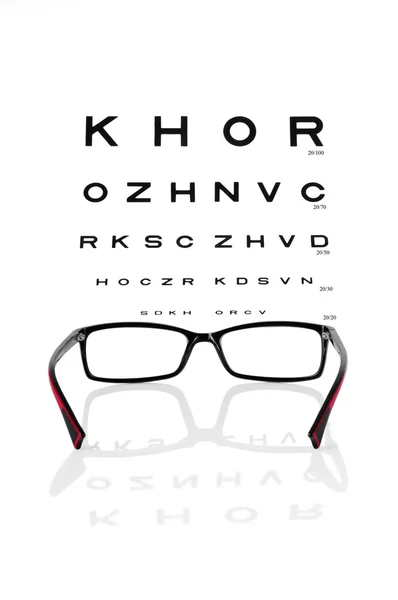 Reading eyeglasses and eye chart — Stock Photo, Image