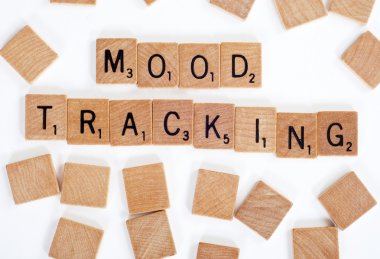 Scrabble tiles spelling out 'Mood Tracking' clipart