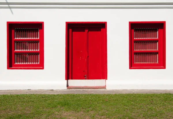 stock image A Red Door and Two Red Window