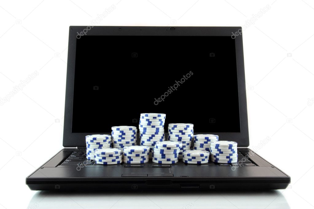 Laptop and white casino chips on keyboard