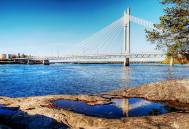 Bridge with reflection in puddle on coast clipart