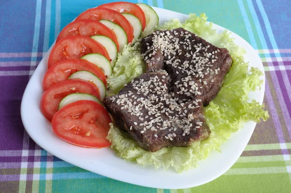 Veal on a piece of lettuce with tomatoes and cucumbers — Stock Photo, Image