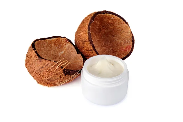 Coconut shells and a jar of cream — Stock Photo, Image