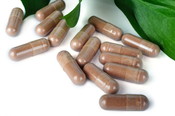 A lot of brown capsules on white background Stock Photo