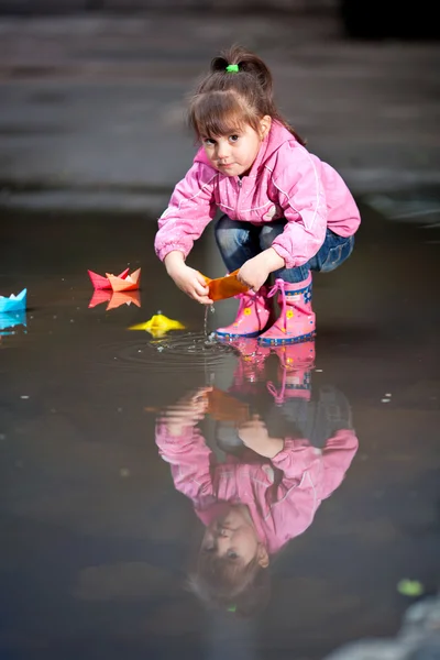Девушка играет в лужу — стоковое фото