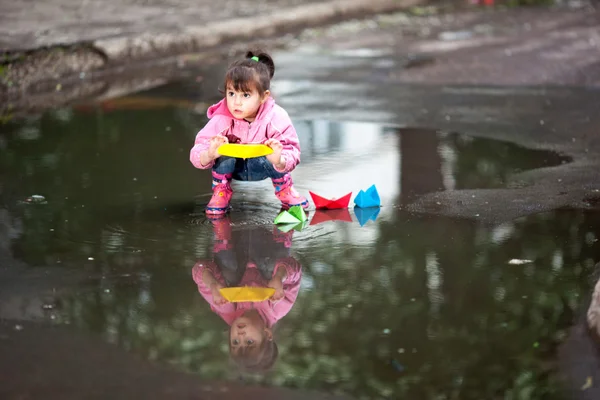 Girl playing in puddle — Stock Photo, Image