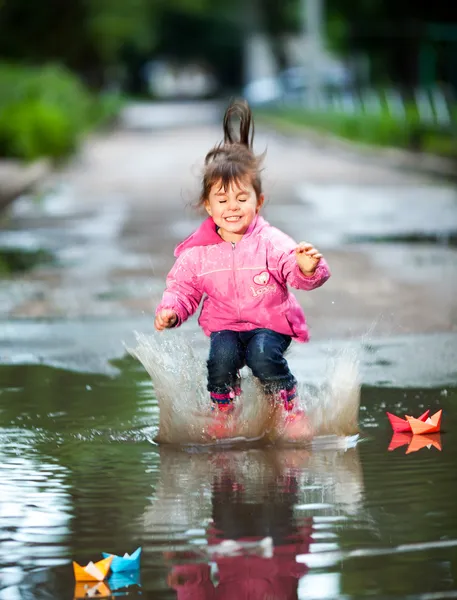 Meisje springt in een plas — Stockfoto