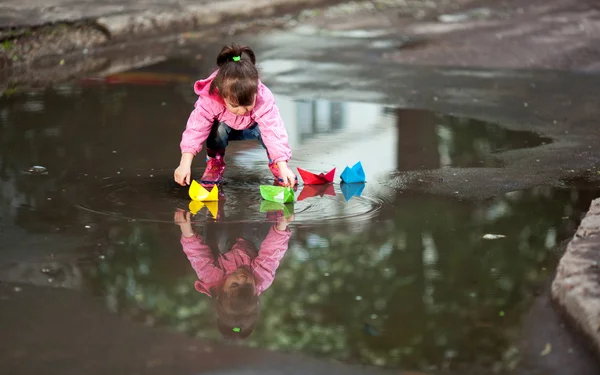Girl playing in puddle Royalty Free Stock Photos