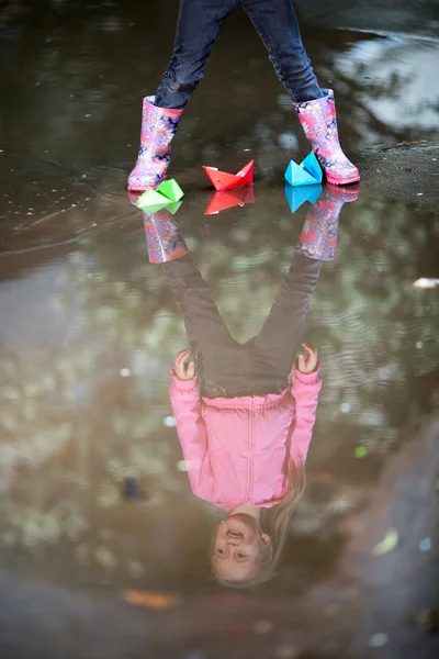 Girl playing in puddle Stock Image