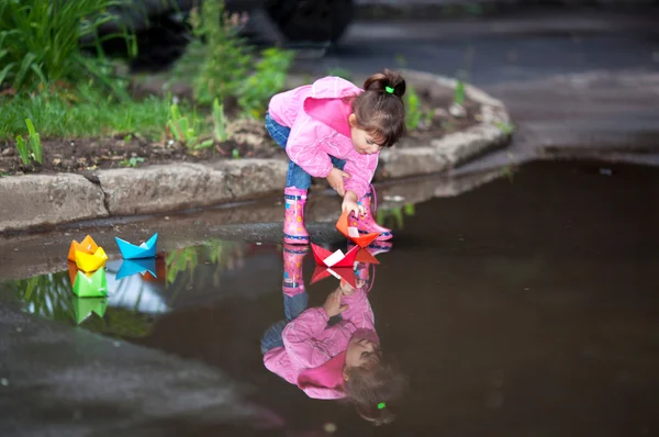 Girl playing in puddle Stock Image