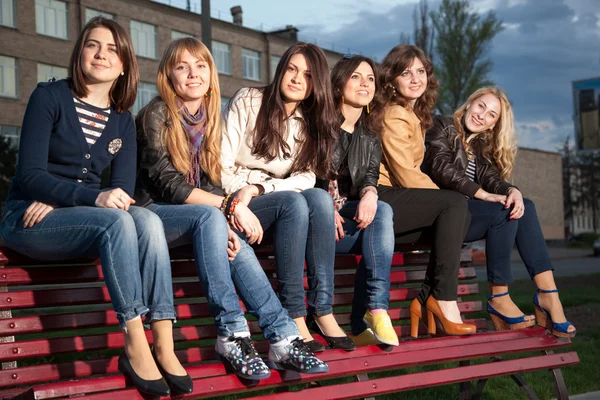 Chicas en un parque de la ciudad en un banco — Foto de Stock