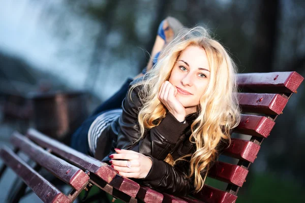 Lány egy városi parkban egy padon — Stock Fotó