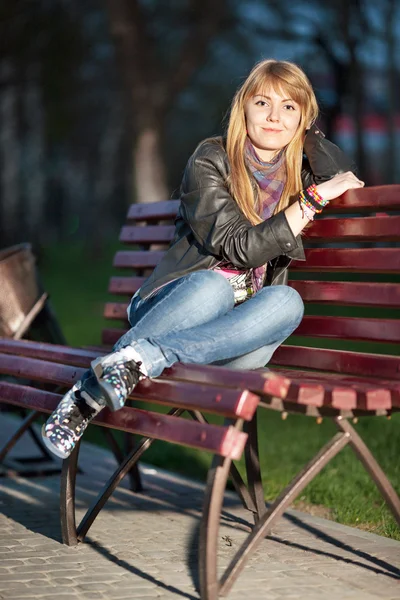 Dívka v městském parku na lavičce — Stock fotografie