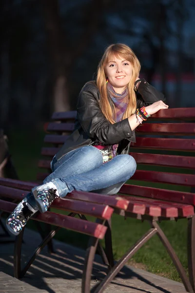 Κορίτσι σε ένα πάρκο της πόλης σε ένα παγκάκι — Φωτογραφία Αρχείου