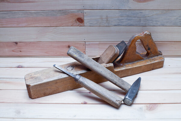 The old carpentry tools lie on the pine boards