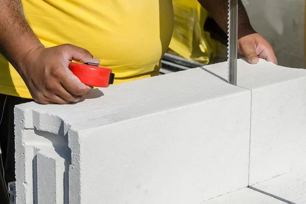 Muratore che lavora con blocchi di costruzione in cemento armato — Foto Stock