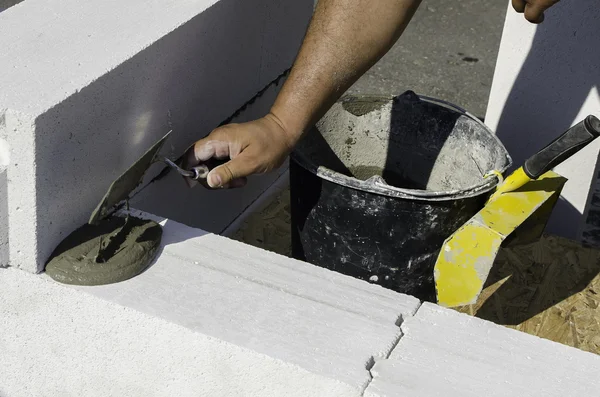 Muratore che lavora con blocchi di costruzione in cemento armato — Foto Stock