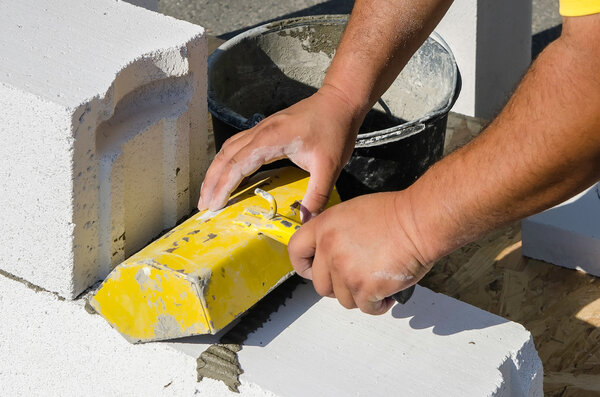 Мейсон работает со строительными блоками из газобетона
