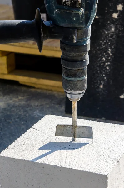 Mason drilling and working with construction blocks made from aerated concrete — Stock Photo, Image