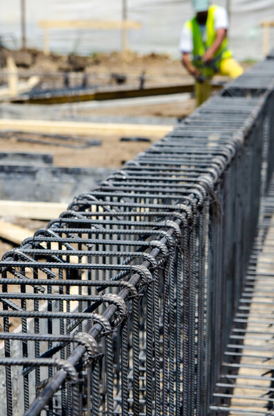 Worker tying reinforcing steel bars for building armature