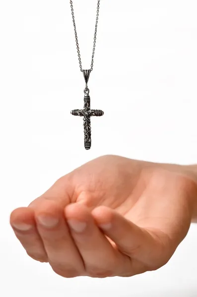 stock image Beautiful cross on chain dropping in hand, shallow depth of field, focus on cross