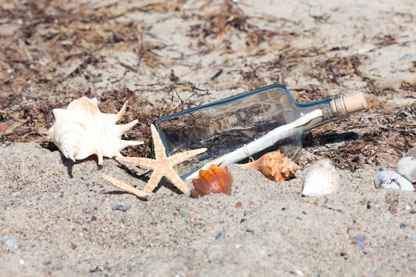 Sahilde deniz ve deniz yıldızı ile şişe bir mesaj — Stok fotoğraf