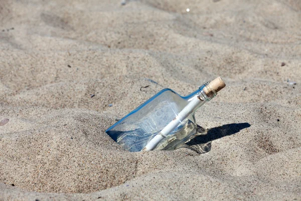 Послание в бутылке, застрявшей в песке на пляже Балтийского моря — стоковое фото
