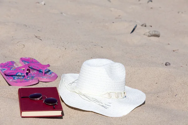 Avec le chapeau de paille et un livre sur la plage — Photo
