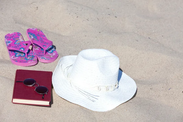 Com o chapéu de palha e um livro na praia — Fotografia de Stock