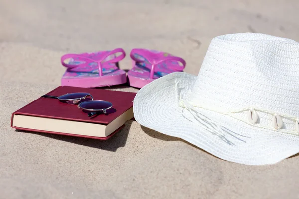 Słomkowy kapelusz i książki na plaży — Zdjęcie stockowe